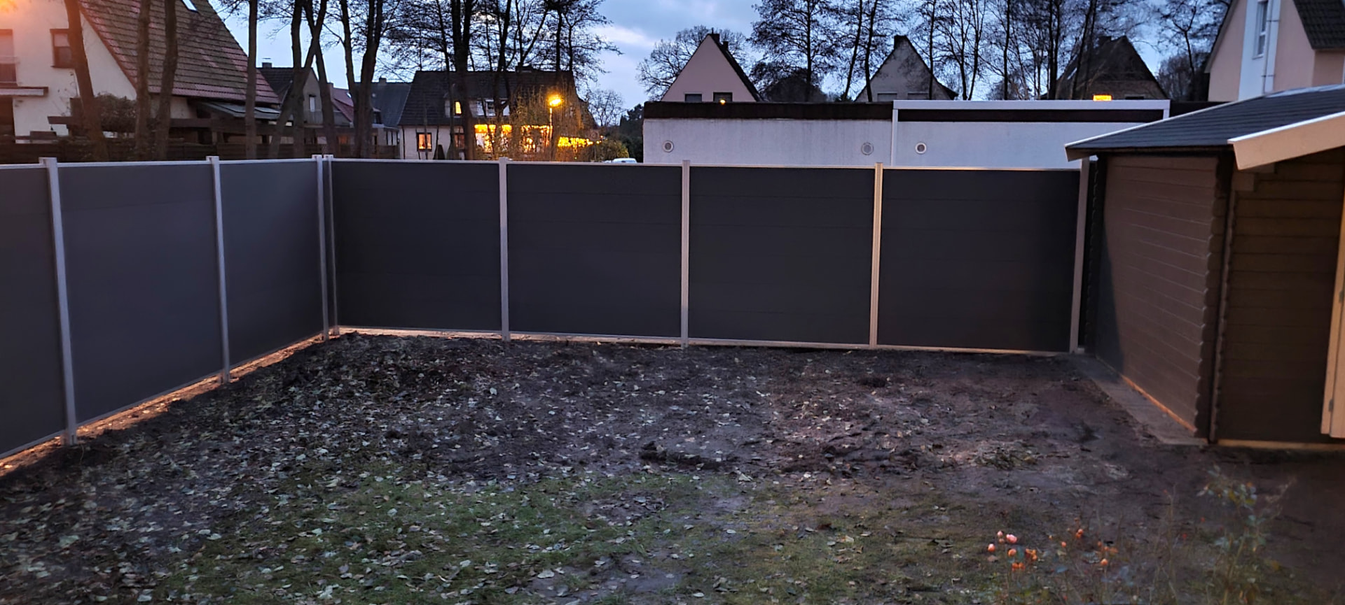 Zaunbau in Bremen: grauer Sichtschutzzaun mit Tor an einem Grundstück