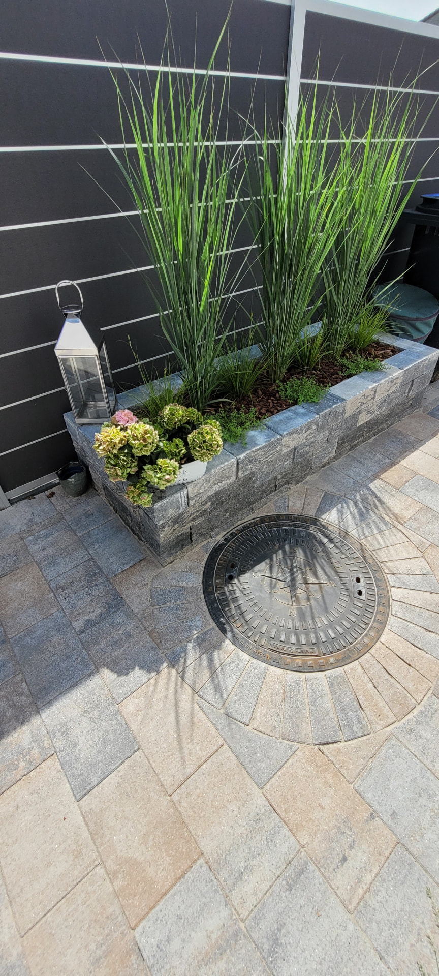 Pflasterarbeiten in Bremen: fertig verlegte Terrasse mit Palisadenhochbeet