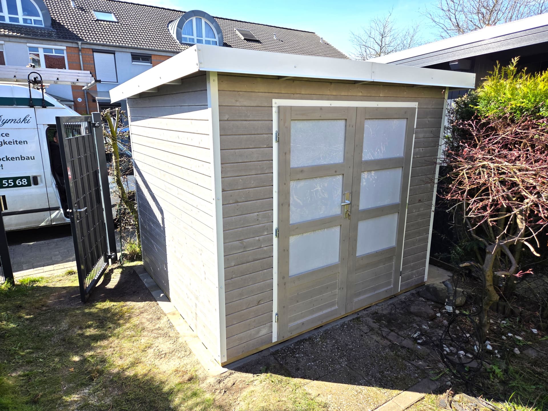 Moderne Gartenhütte in Grau mit großen Milchglasfüllungen