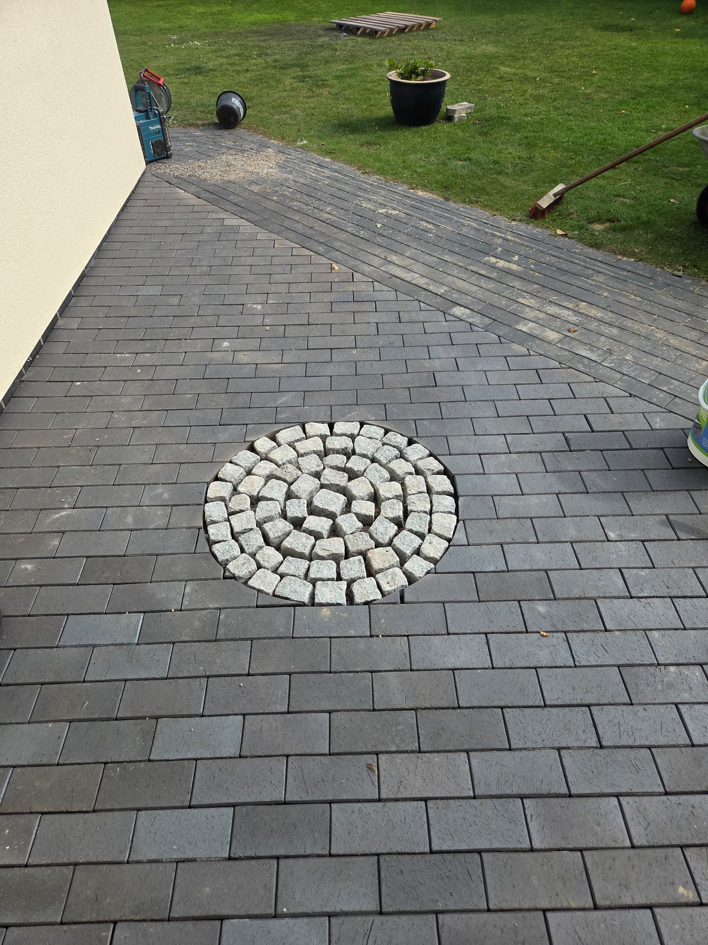 Pflasterarbeiten in Bremen: fertige Fläche mit Kopfsteinpflaster-Motiv um den Gully